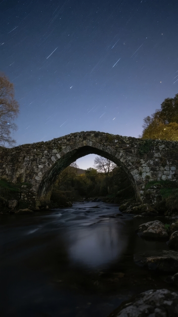 夜空下石桥横跨河流的宁静景象