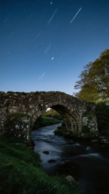 夜空流星划过拱桥下的河流与绿树