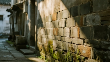 阳光洒在古旧砖墙上的小巷
