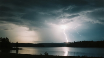 雷电划破夜空照亮湖面与森林