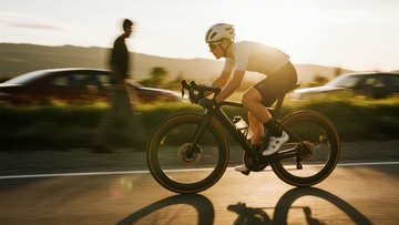 夕阳下骑行者在公路上疾驰