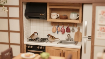 微型厨房模型中三只麻雀栖息在灶台上