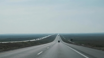 空旷公路上车辆行驶的远景画面