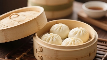 竹制蒸笼中摆放着四个白色包子