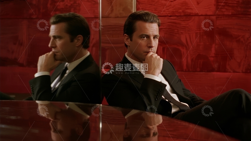 高清大图下载【趣麦麦图】身着西装的男子倚靠在红色背景前双手托腮