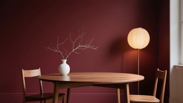 深红色墙面的简约餐厅角落摆放着木质桌椅和纸灯笼