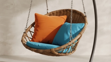 藤编吊椅配橙蓝靠垫悬挂于简约室内空间