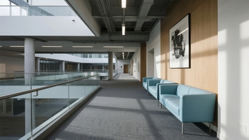 现代办公楼内部走廊设有蓝色沙发和艺术挂画