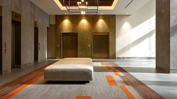 现代建筑大厅内设有电梯和装饰性地毯