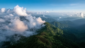 云海缭绕的翠绿山峦高空俯瞰图
