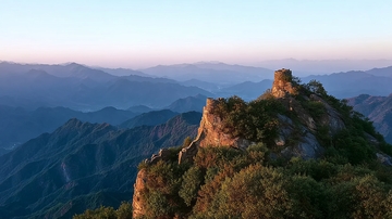 山巅古塔与层叠山脉的日落景象