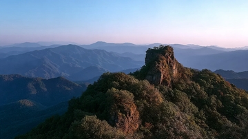 山巅巨石与层叠山脉的日落景象