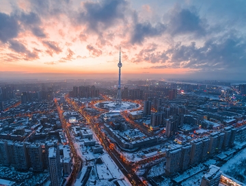 雪后城市日出时分高空俯瞰塔楼与街道