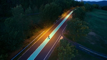 夜晚骑行者在灯光照亮的道路上穿行