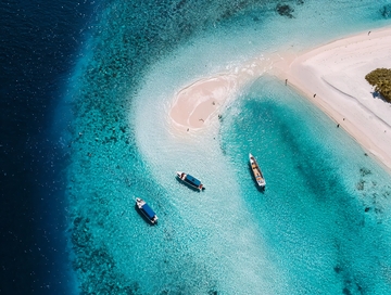 热带岛屿沙滩与清澈海水中的几艘小船