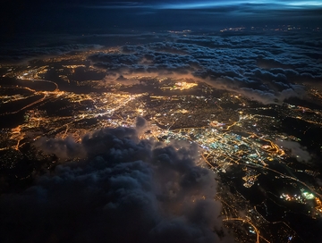 高空俯瞰夜幕下灯火辉煌的城市与云海