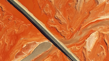 橙色地貌中的蜿蜒河流与道路景观