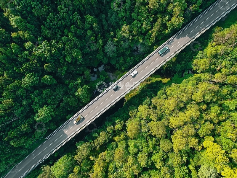 高清大图下载【趣麦麦图】俯瞰视角下车辆行驶在绿树环绕的桥梁上