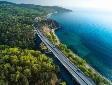 沿海公路蜿蜒穿过绿树成荫的海岸线