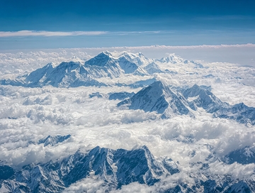 雪山群峰高耸云海之上蓝天映衬壮丽景观