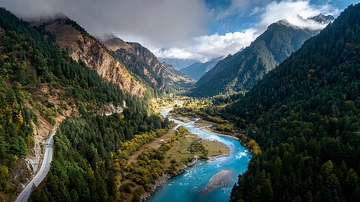 壮丽山谷中蜿蜒河流与茂密森林全景