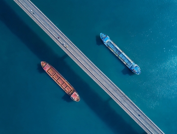 俯瞰视角下桥梁上行驶的两艘货船