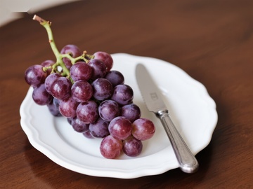 盘中紫葡萄与刀具