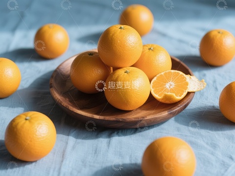 新鲜橙子摆盘，背景蓝色布料