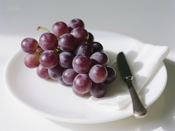 盘中紫葡萄与刀具