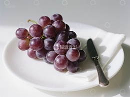 盘中紫葡萄与刀具