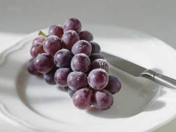 盘中紫葡萄与刀具