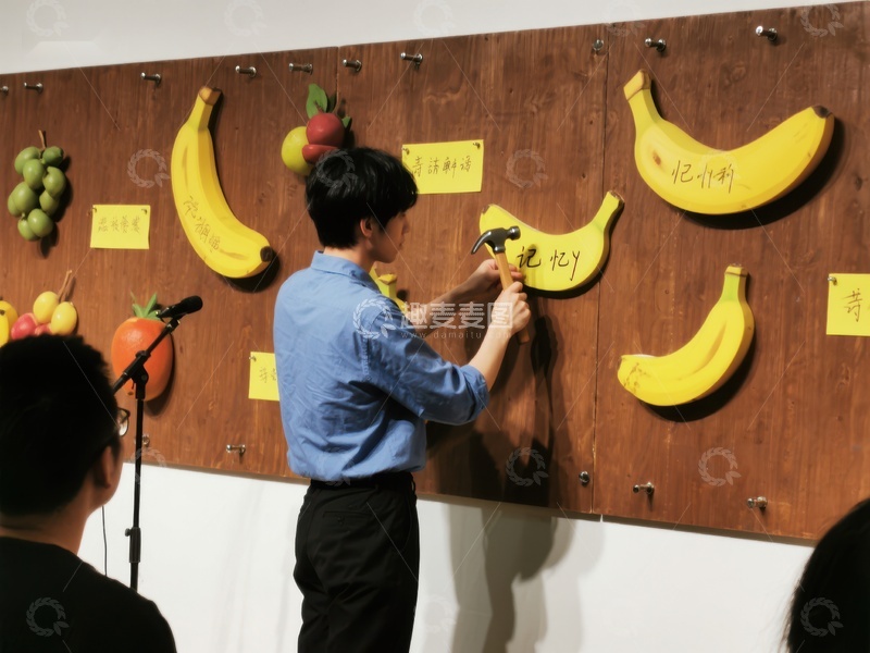 高清大图下载【趣麦麦图】男子在木板上钉香蕉形状装饰