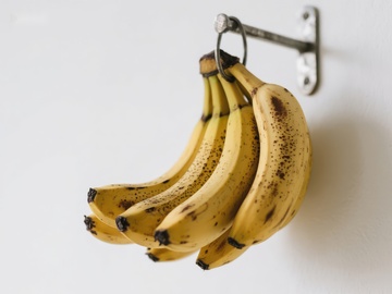 墙上挂钩挂着的成熟香蕉