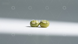 两颗绿色豆子静置于白色背景