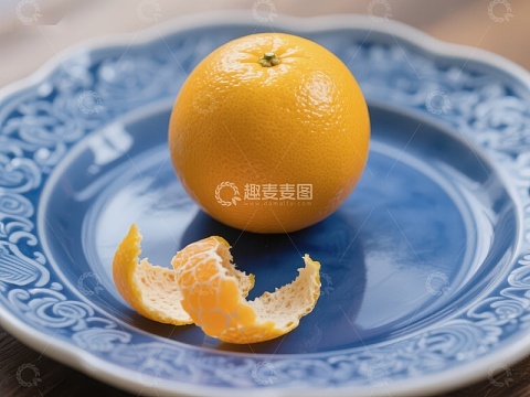 橙子与果皮置于蓝色花纹盘中