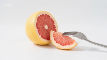 切开的葡萄柚与叉子