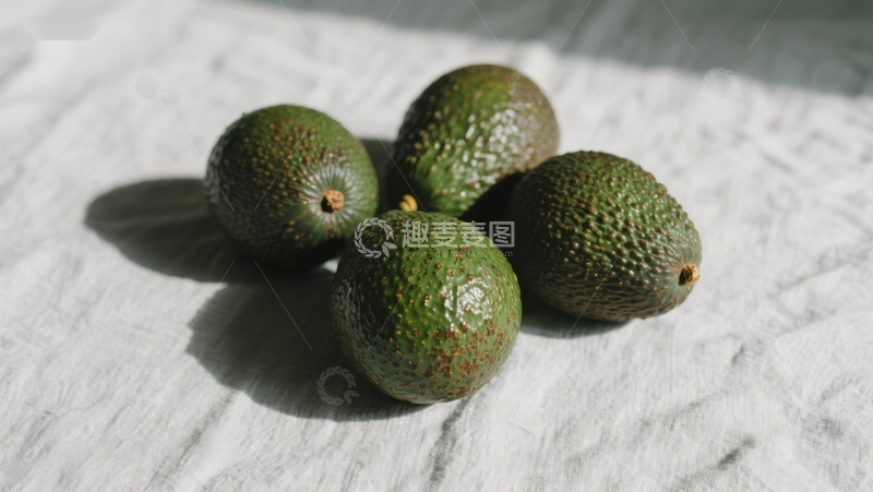 高清大图下载【趣麦麦图】四个牛油果静置于白色布料上
