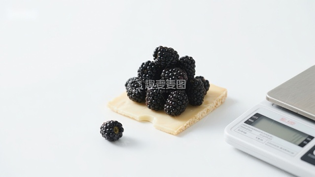 黑莓放置在饼干上，旁边有电子秤