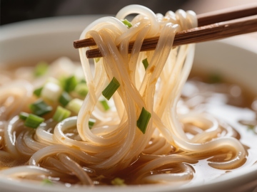 筷子夹起透明面条，热汤飘香