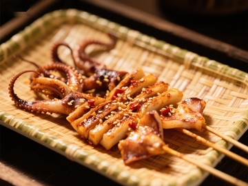 烤鱿鱼串，撒上芝麻和辣椒