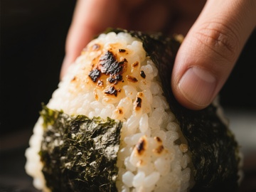 手握烤海苔饭团特写