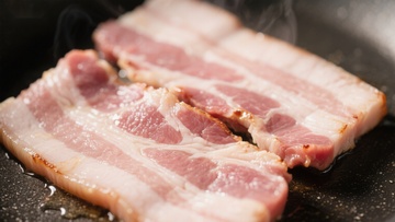 煎锅中的培根正在烹饪