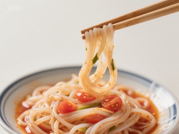 筷子夹起的番茄凉面