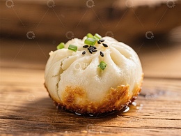 煎制包子，撒以葱花和芝麻