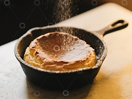 铸铁锅中的松饼撒上糖粉