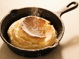 铸铁锅中的松饼撒糖