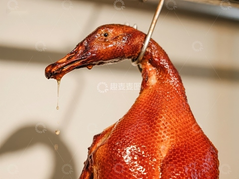 烤鸭悬挂滴油，色泽诱人