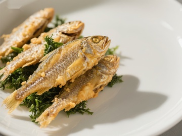 金黄酥脆的炸鱼配绿叶蔬菜