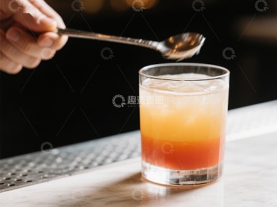 调酒师用勺搅拌橙色鸡尾酒