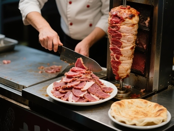 厨师切割旋转烤肉，准备美食